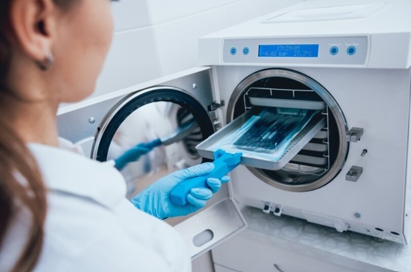 A clinician loading a benchtop steam steriliser